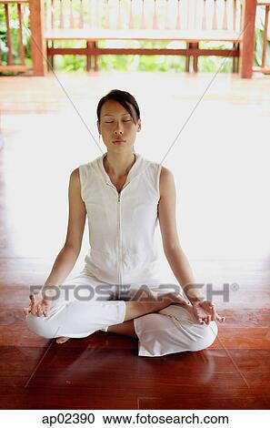 Stock Image - Woman sitting in lotus position . Fotosearch