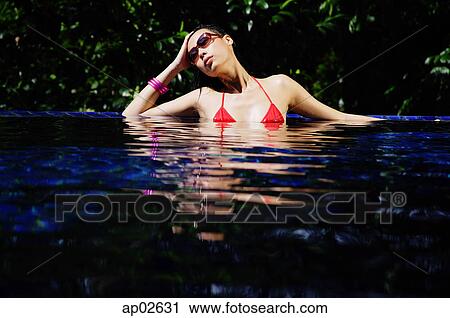 Woman sitting in swimming pool, hand on head View Large Photo Image Stock Image - Woman sitting in swimming pool, hand on head . Fotosearch