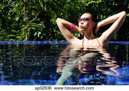 Woman sitting in swimming pool, sunbathing View Large Photo Image Stock Photograph - Woman sitting in swimming pool, sunbathing. Fotosearch
