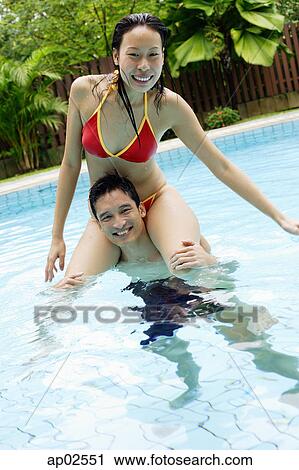 Woman sitting on mans shoulders in swimming pool View Large Photo Image Stock Image - Woman sitting on mans shoulders in swimming pool . Fotosearch