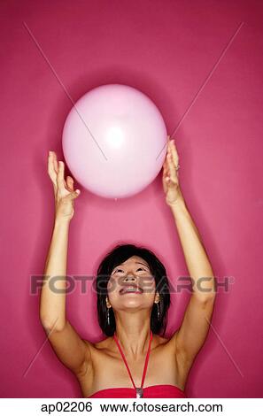 Woman tossing pink balloon View Large Photo Image Stock Photograph - Woman tossing pink balloon . Fotosearch