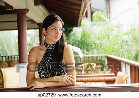Woman wearing halter top, leaning on railing, arms crossed View Large Photo Image Stock Photo - Woman wearing halter top, leaning on railing, arms crossed . Fotosearch