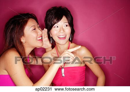 Woman whispering to friend and pointing with finger View Large Photo Image Stock Image - Woman whispering to friend and pointing with finger . Fotosearch
