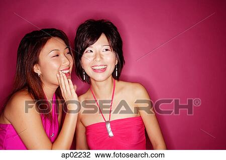 Stock Image - Woman whispering to friend . Fotosearch