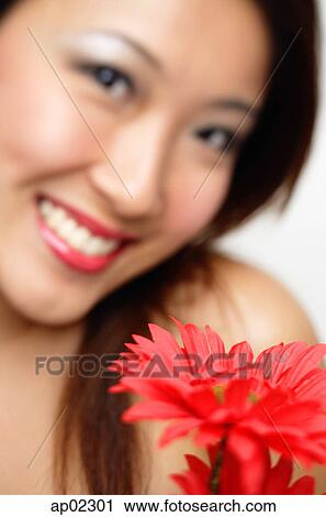Woman with flower, smiling, focus on the foreground View Large Photo Image Stock Image - Woman with flower, smiling, focus on the foreground . Fotosearch