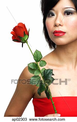 Stock Image - Woman with single stalk of rose . Fotosearch