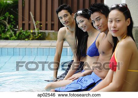 Young adult couples sitting at edge of swimming pool, side view View Large Photo Image Stock Photograph - Young adult couples sitting at edge of swimming pool, side view . Fotosearch