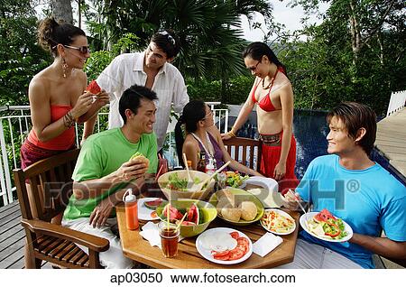Young adults having a meal on patio View Large Photo Image Stock Image - Young adults having a meal on patio . Fotosearch