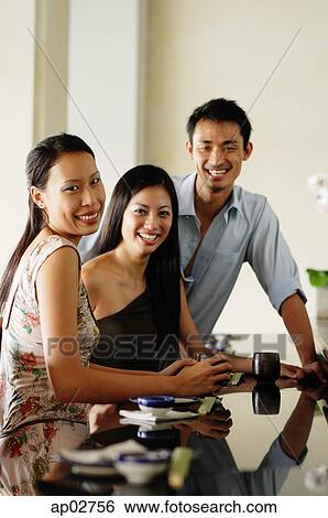 Stock Photograph - Young adults in restaurant, looking at camera . Fotosearch