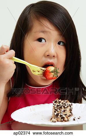 Young girl eating strawberry with fork View Large Photo Image Picture - Young girl eating strawberry with fork. Fotosearch