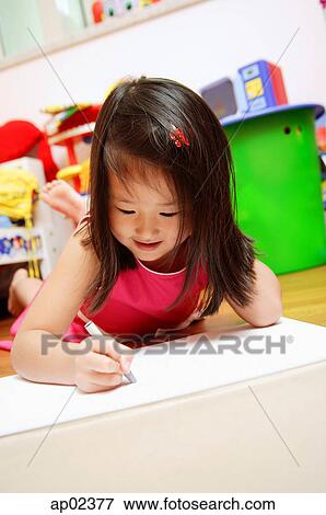 Stock Photo - Young girl lying on floor drawing . Fotosearch