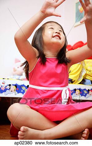 Young girl sitting cross-legged, looking up, hands raised View Large Photo Image Stock Image - Young girl sitting cross-legged, looking up, hands raised. Fotosearch