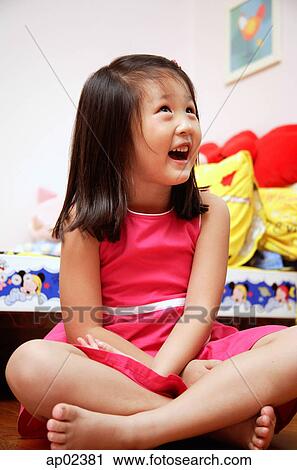 Young girl sitting cross-legged, looking away, smiling View Large Photo Image Stock Image - Young girl sitting cross-legged, looking away, smiling. Fotosearch