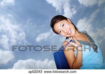 Stock Image - Young woman carrying shopping bags . Fotosearch