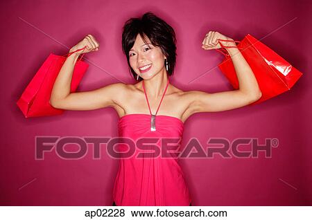 Young woman carrying shopping bags, facing camera View Large Photo Image Stock Photo - Young woman carrying shopping bags, facing camera . Fotosearch
