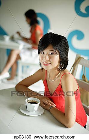 Young woman in cafe, having coffee, looking at camera View Large Photo Image Stock Image - Young woman in cafe, having coffee, looking at camera . Fotosearch