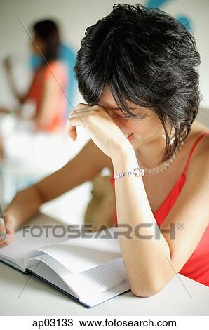 Young woman in cafe, reading notebook, hand on head View Large Photo Image Stock Image - Young woman in cafe, reading notebook, hand on head . Fotosearch