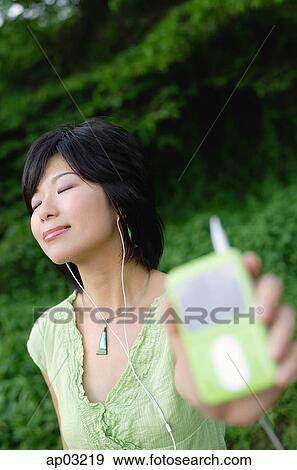 Young woman listening to mp3 player, eyes closed View Large Photo Image Stock Photo - Young woman listening to mp3 player, eyes closed. Fotosearch