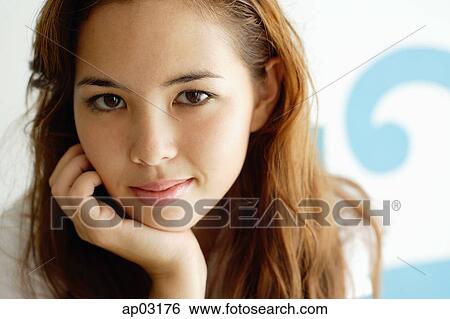 Young woman looking at camera, hand on chin View Large Photo Image Stock Photograph - Young woman looking at camera, hand on chin . Fotosearch