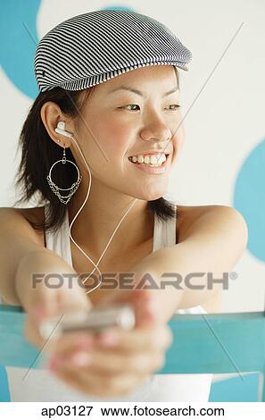 Young woman wearing beret, listening to MP3 player View Large Photo Image Stock Photo - Young woman wearing beret, listening to MP3 player . Fotosearch