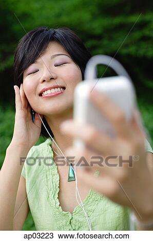 Young woman with mp3 player, eyes closed, smiling View Large Photo Image Stock Image - Young woman with mp3 player, eyes closed, smiling . Fotosearch