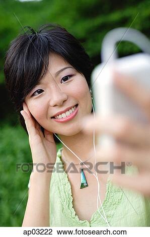 Young woman with mp3 player, smiling View Large Photo Image Stock Image - Young woman with mp3 player, smiling . Fotosearch