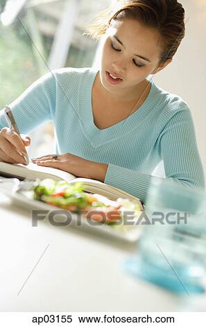 Young woman writing in notebook View Large Photo Image Stock Photography - Young woman writing in notebook . Fotosearch
