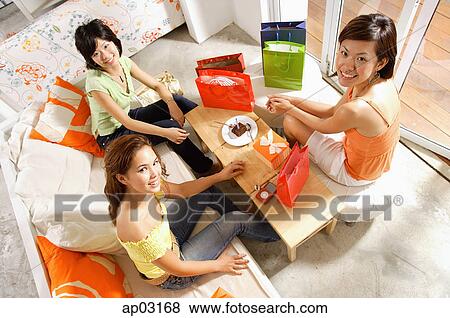 Young women at home, celebrating birthday, looking up at camera View Large Photo Image Stock Photo - Young women at home, celebrating birthday, looking up at camera . Fotosearch
