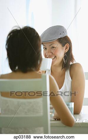 Stock Photo - Young women in cafe, having coffee . Fotosearch
