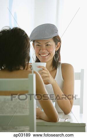 Young women in cafe, having coffee, sitting face to face View Large Photo Image Stock Photo - Young women in cafe, having coffee, sitting face to face . Fotosearch