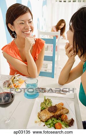 Young women in cafe, having lunch, talking View Large Photo Image Stock Photography - Young women in cafe, having lunch, talking . Fotosearch
