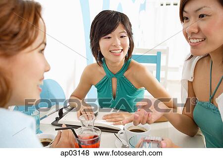 Young women in cafe, talking View Large Photo Image Stock Photo - Young women in cafe, talking. Fotosearch