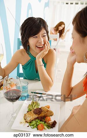 Young women talking over lunch in cafe View Large Photo Image Stock Photo - Young women talking over lunch in cafe . Fotosearch