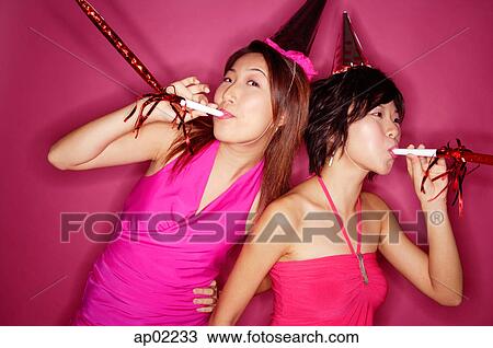 Young women with noisemakers and party hats View Large Photo Image Stock Image - Young women with noisemakers and party hats . Fotosearch