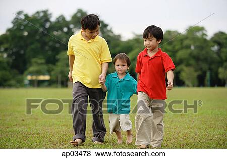 Boys walking on grass, side by side View Large Photo Image Stock Photo - Boys walking on grass, side by side . Fotosearch