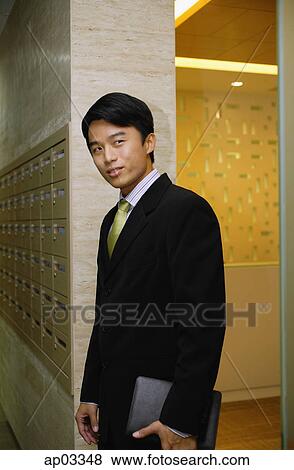 Businessman holding folder, standing View Large Photo Image Stock Photo - Businessman holding folder, standing. Fotosearch