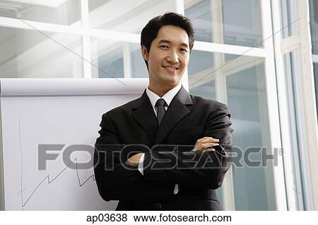 Businessman looking at camera, arms crossed, smiling View Large Photo Image Stock Photo - Businessman looking at camera, arms crossed, smiling . Fotosearch