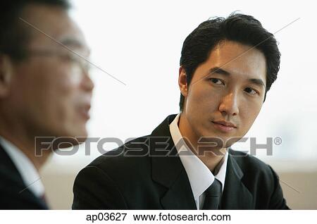 Businessman looking at person next to him View Large Photo Image Stock Photo - Businessman looking at person next to him . Fotosearch