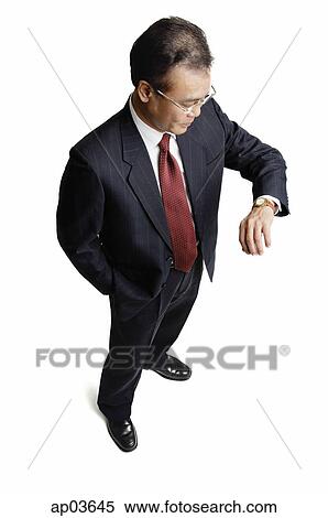 Stock Photography - Businessman looking at watch. Fotosearch