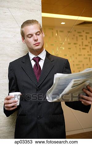 Businessman reading newspaper, holding paper cup View Large Photo Image Stock Image - Businessman reading newspaper, holding paper cup . Fotosearch