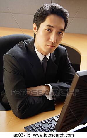 Businessman sitting at desk, arms crossed, looking at camera View Large Photo Image Stock Photography - Businessman sitting at desk, arms crossed, looking at camera. Fotosearch