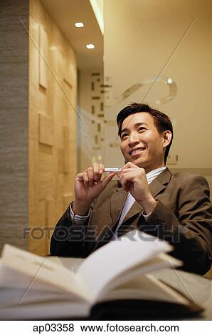 Stock Photo - Businessman sitting, leaning back and smiling. Fotosearch