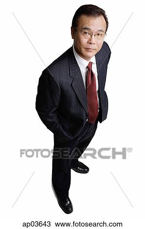 Businessman standing, looking at camera View Large Photo Image Stock Image - Businessman standing, looking at camera. Fotosearch