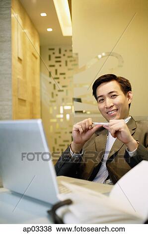 Stock Photo - Businessman standing with arm outstretched and hand in pocket. Fotosearch