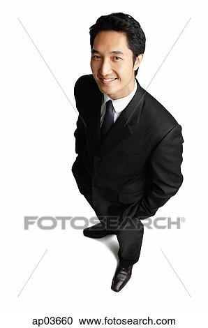 Businessman standing with hands in pockets, smiling at camera View Large Photo Image Stock Image - Businessman standing with hands in pockets, smiling at camera . Fotosearch