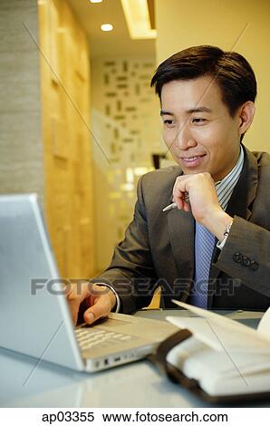 Businessman using laptop, hand on chin View Large Photo Image Stock Photography - Businessman using laptop, hand on chin . Fotosearch