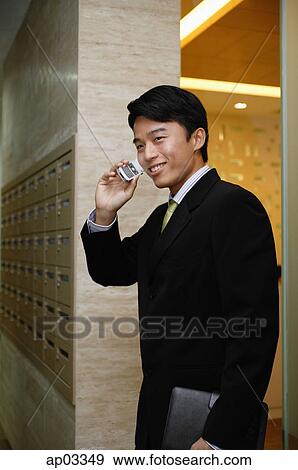 Businessman using mobile phone, smiling View Large Photo Image Stock Photo - Businessman using mobile phone, smiling. Fotosearch