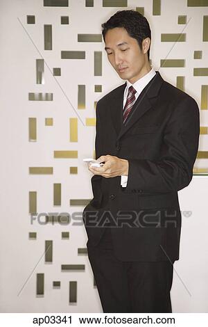 Stock Image - Businessman using mobile phone, text messaging. Fotosearch