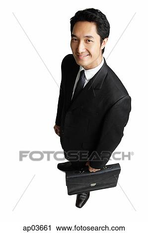 Businessman with briefcase, smiling at camera View Large Photo Image Stock Image - Businessman with briefcase, smiling at camera . Fotosearch