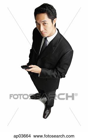 Businessman with mobile phone, looking at camera View Large Photo Image Picture - Businessman with mobile phone, looking at camera . Fotosearch